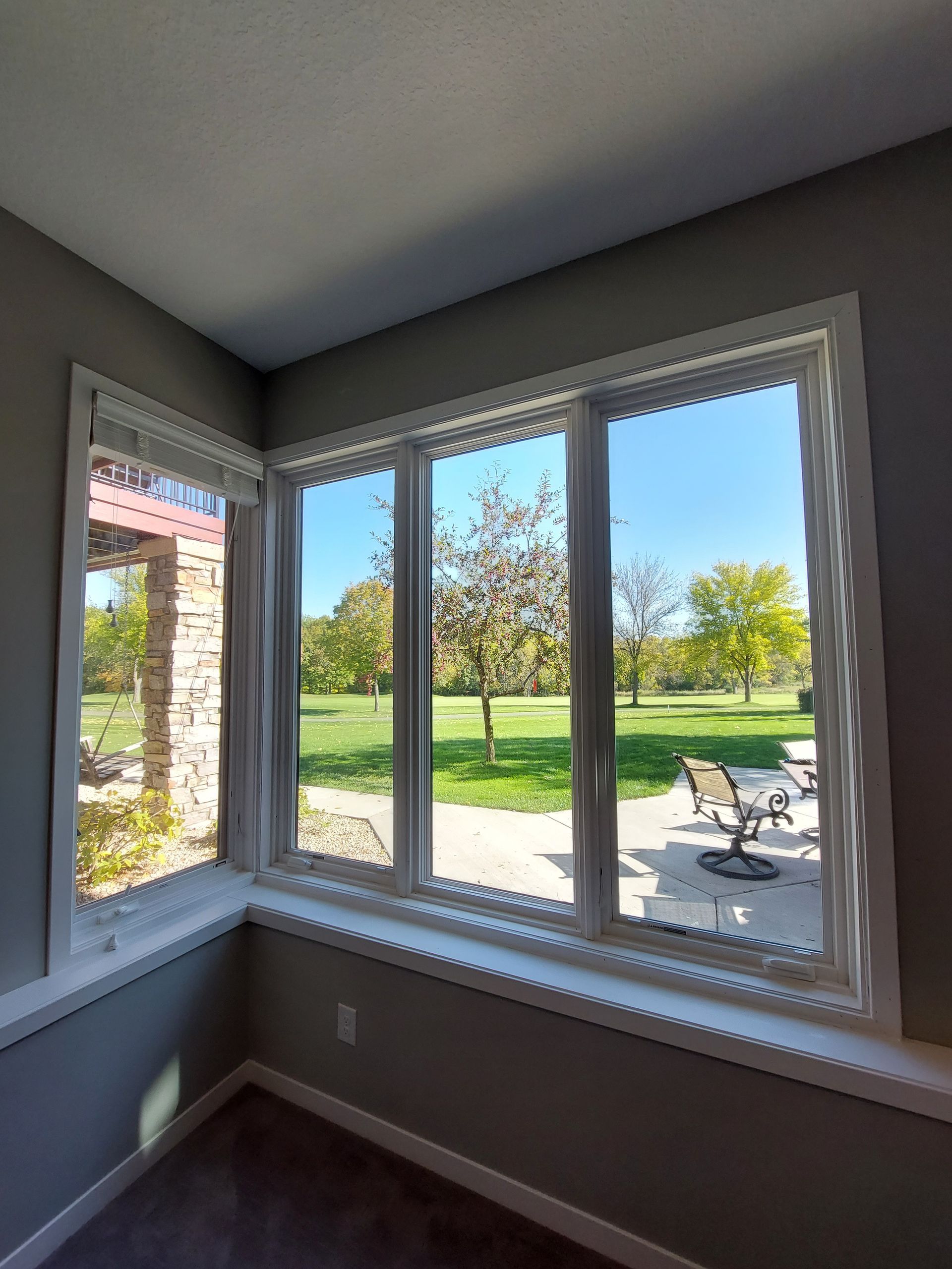 a room with a lot of windows and a view of a golf course