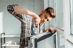 Man Repairing The Window