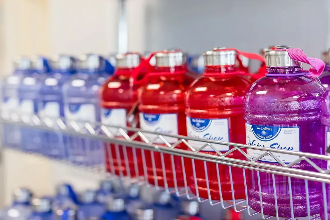 A shelf filled with water bottles of different colors.