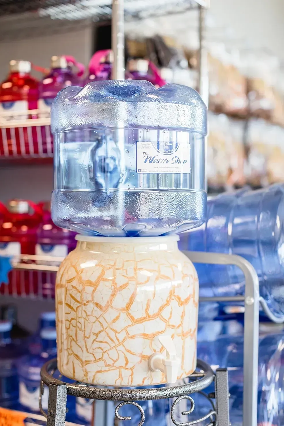 A bottle of water is sitting on top of a ceramic container.