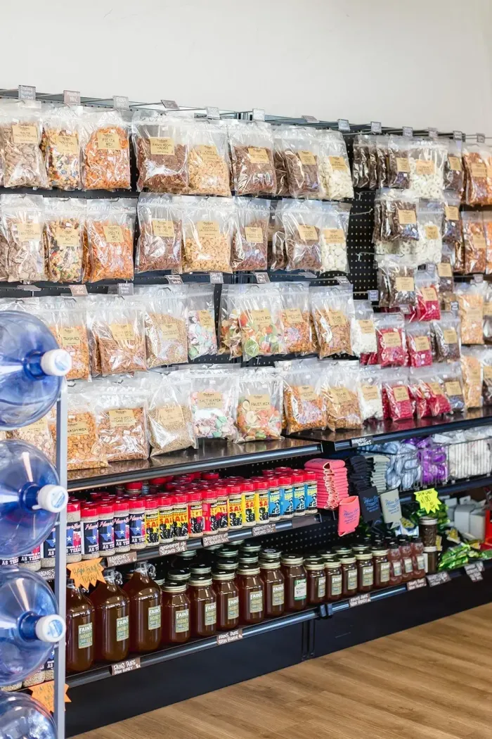 A grocery store aisle filled with bags of food and bottles of water.