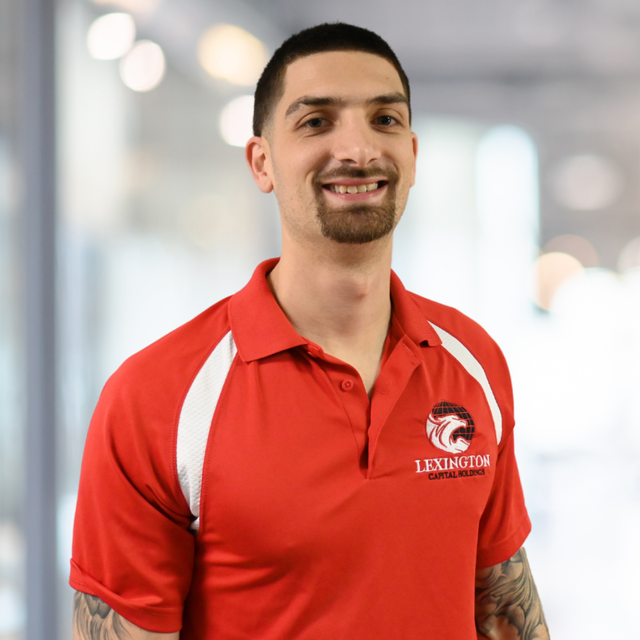 Man in red Lexington polo shirt smiling.