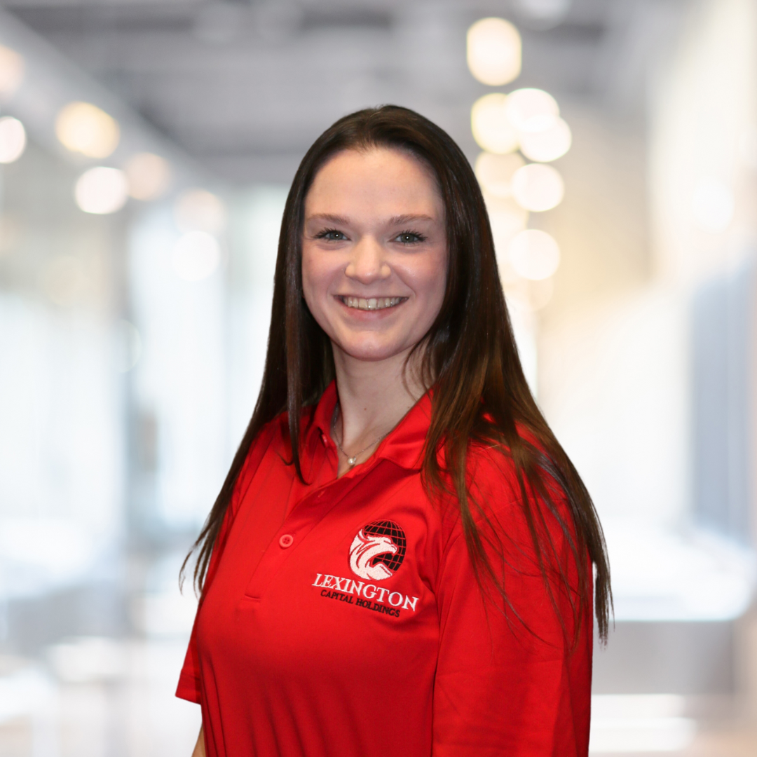Woman with long brown hair smiles, wearing a red 