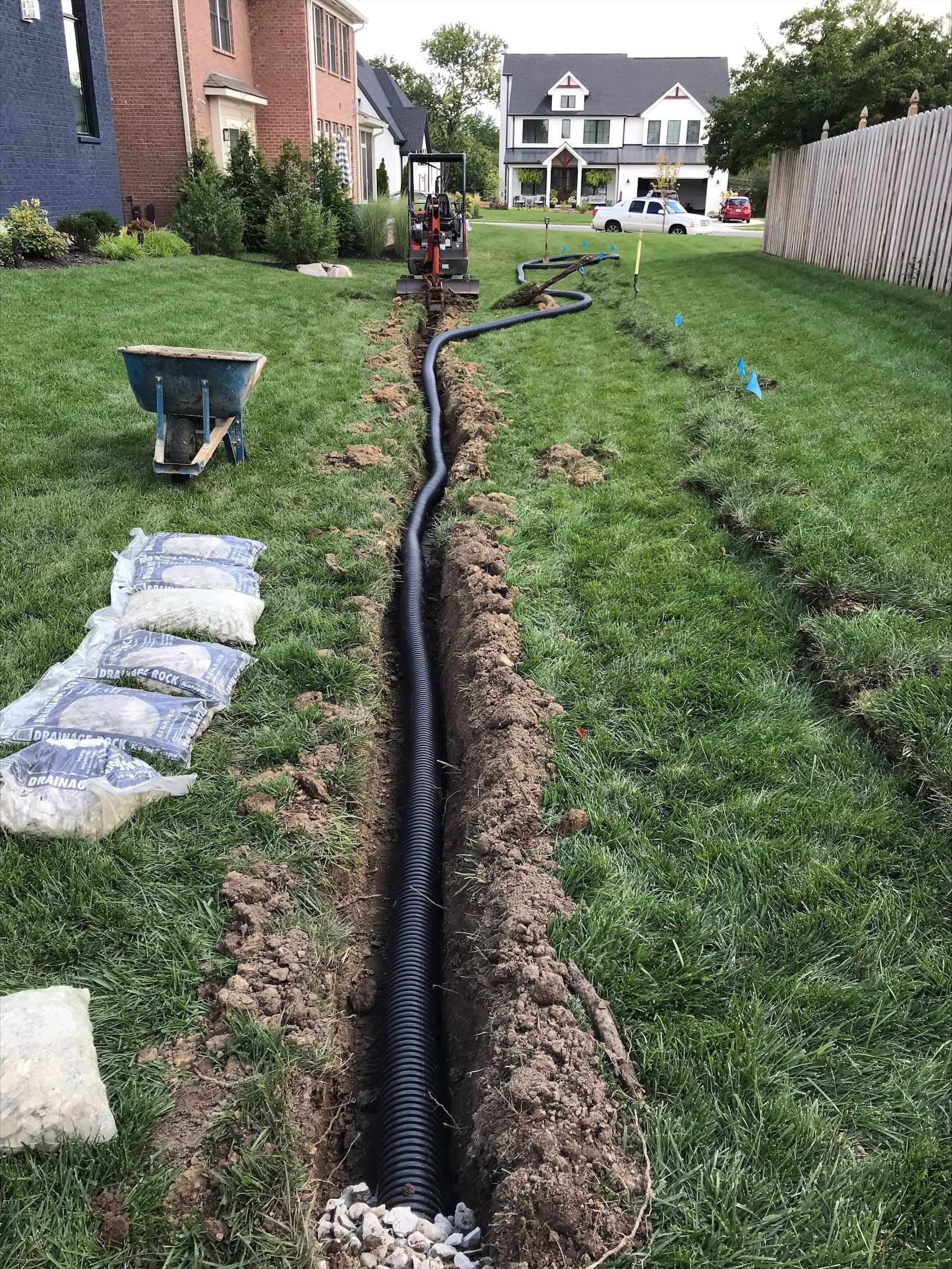 worker inserting tube into drainage plot
