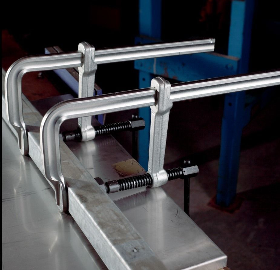 A pair of metal clamps sitting on top of a piece of metal