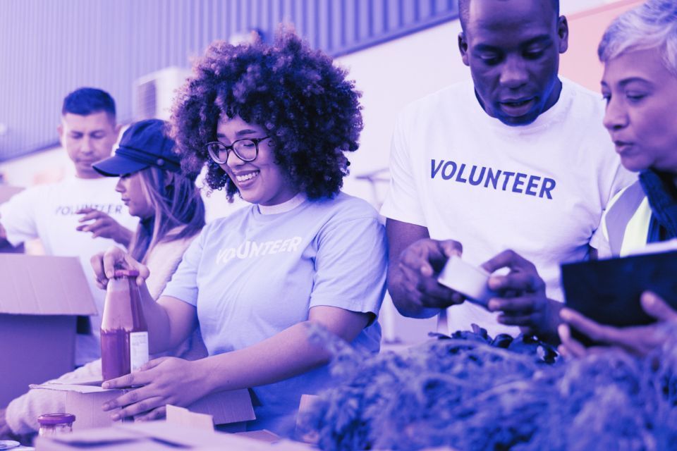 A group of volunteers are standing around a table.