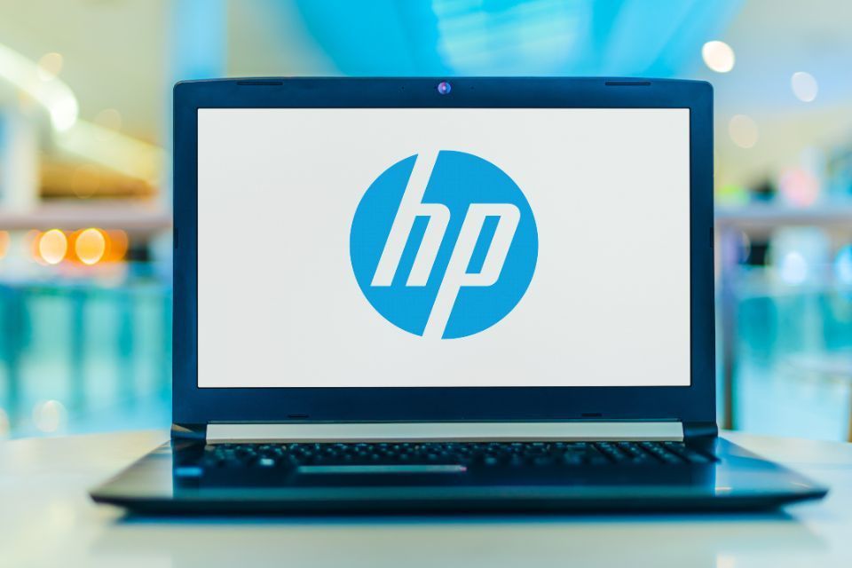 A laptop computer with the hp logo on the screen is sitting on a table.