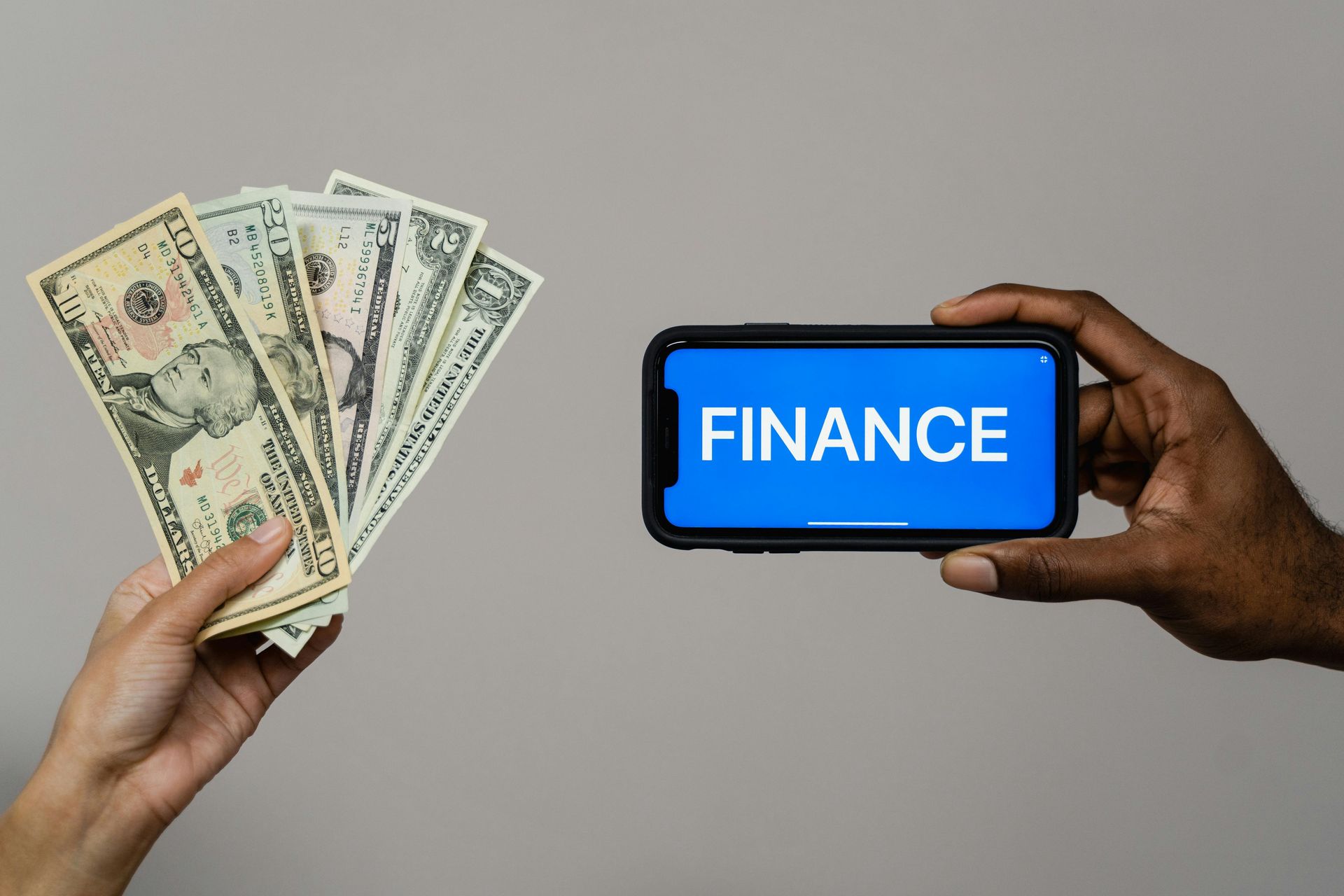 A man is holding a cell phone with the word finance on it.