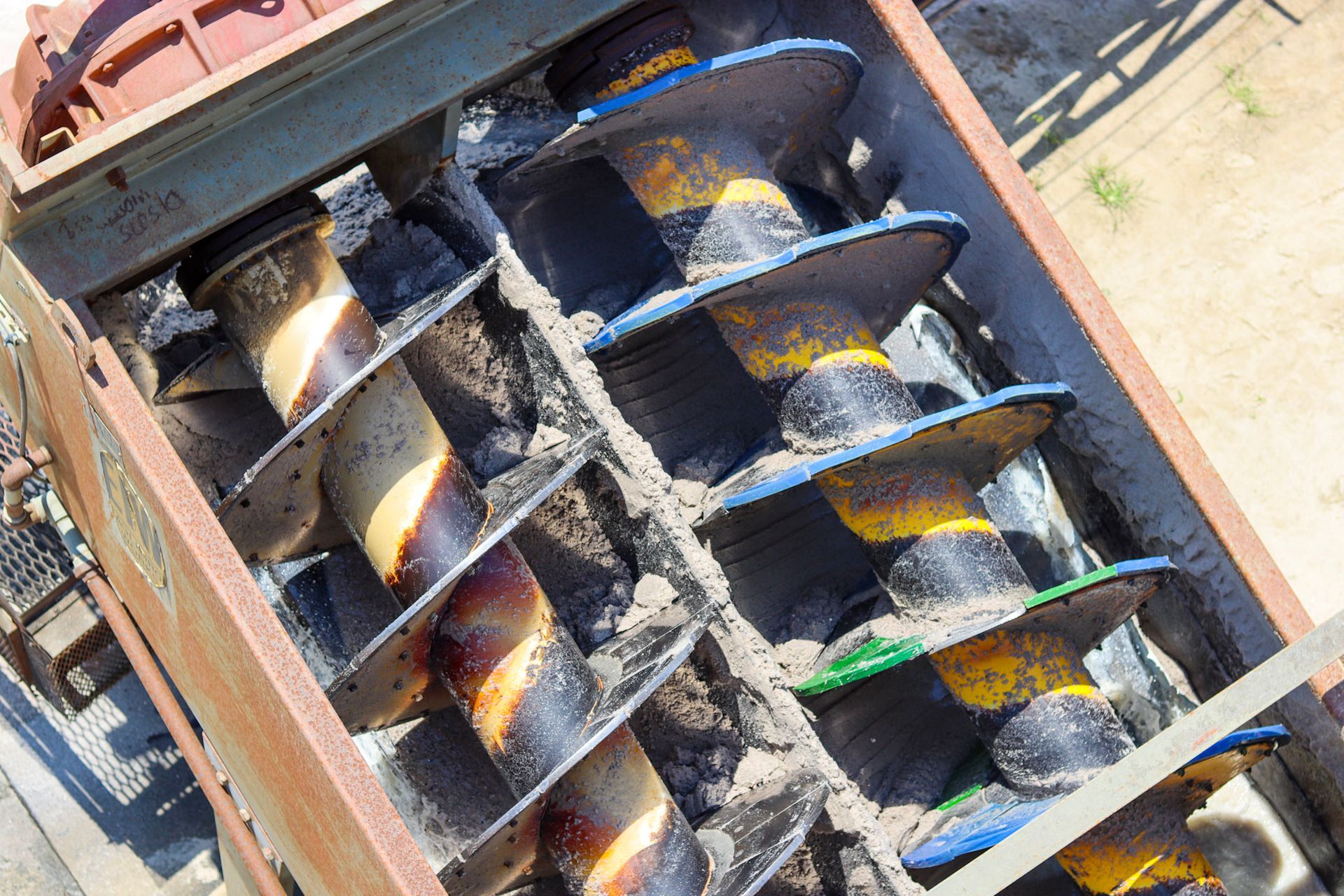 Gloved hand holding a pile of small, multicolored pebbles.