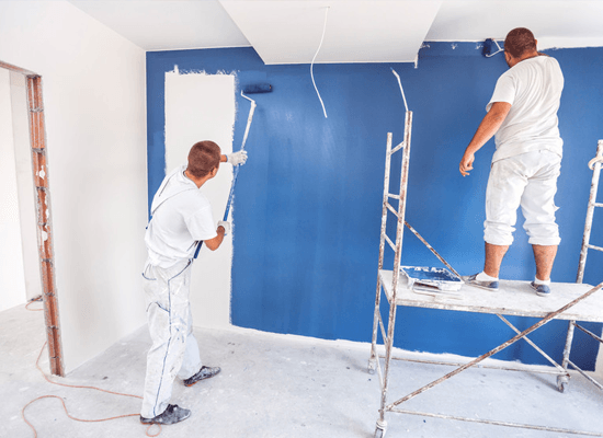 House painters beginning to paint a large blue wall