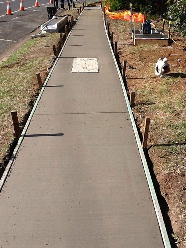 A concrete walkway is being built next to a road