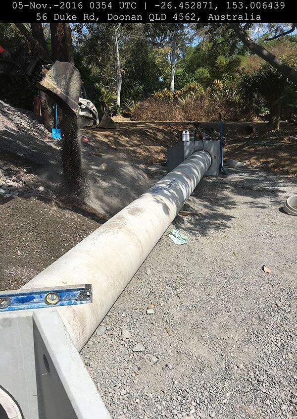 A large concrete pipe is being measured with a level.