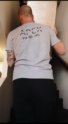 A man is carrying a box up a set of stairs.