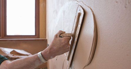 a worker plastering a wall 