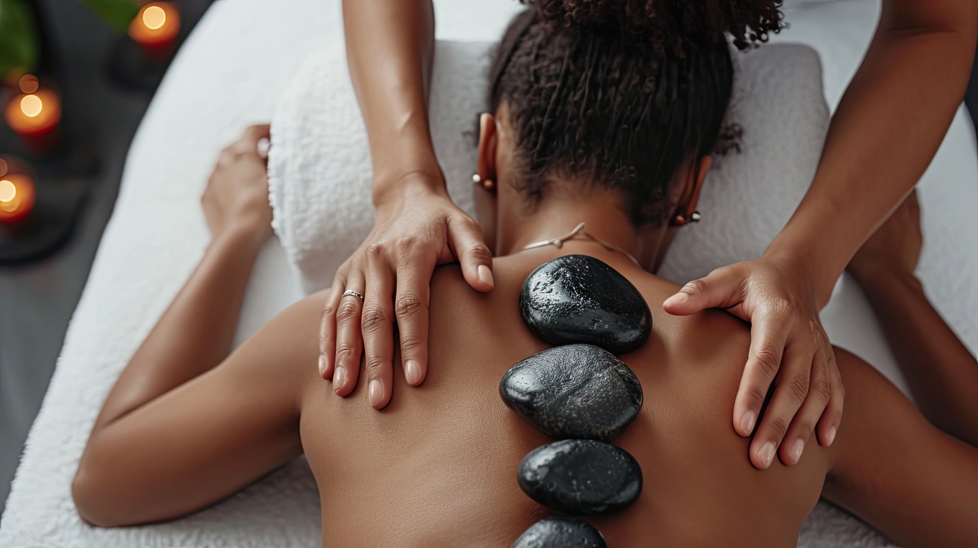 A woman is getting a hot stone massage at a spa.