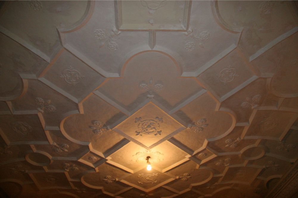 Decorative embossed ceiling with a lit central ceiling fixture casting a warm glow