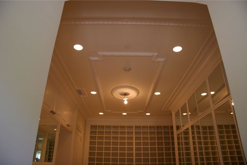 White coffered ceiling with recessed lights and a central decorative medallion in a hallway