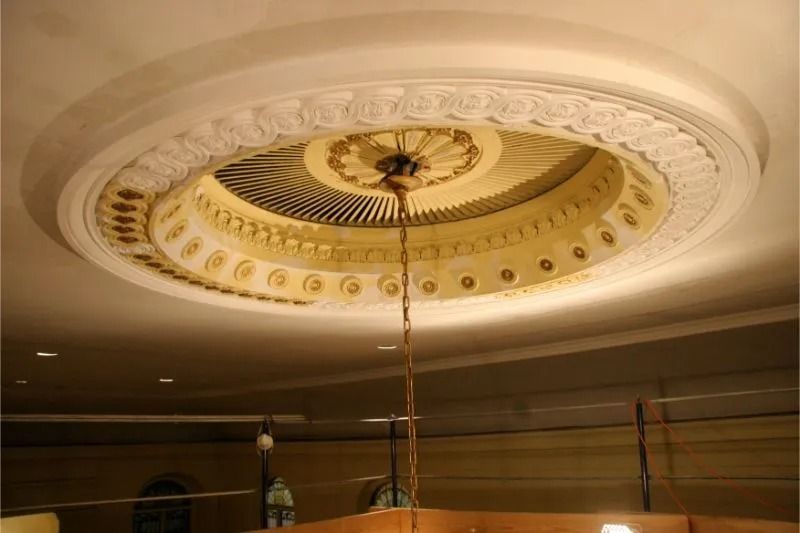 Ornate circular ceiling medallion with gold and cream detailing in an elegant interior