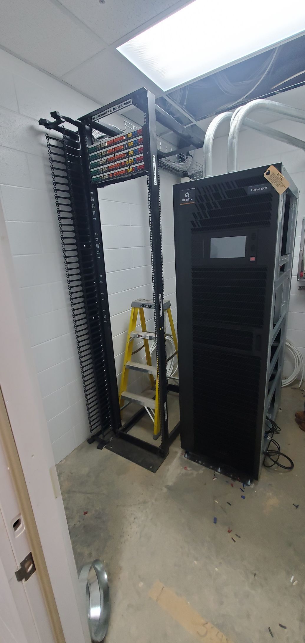 A room with a ladder and a server in it.