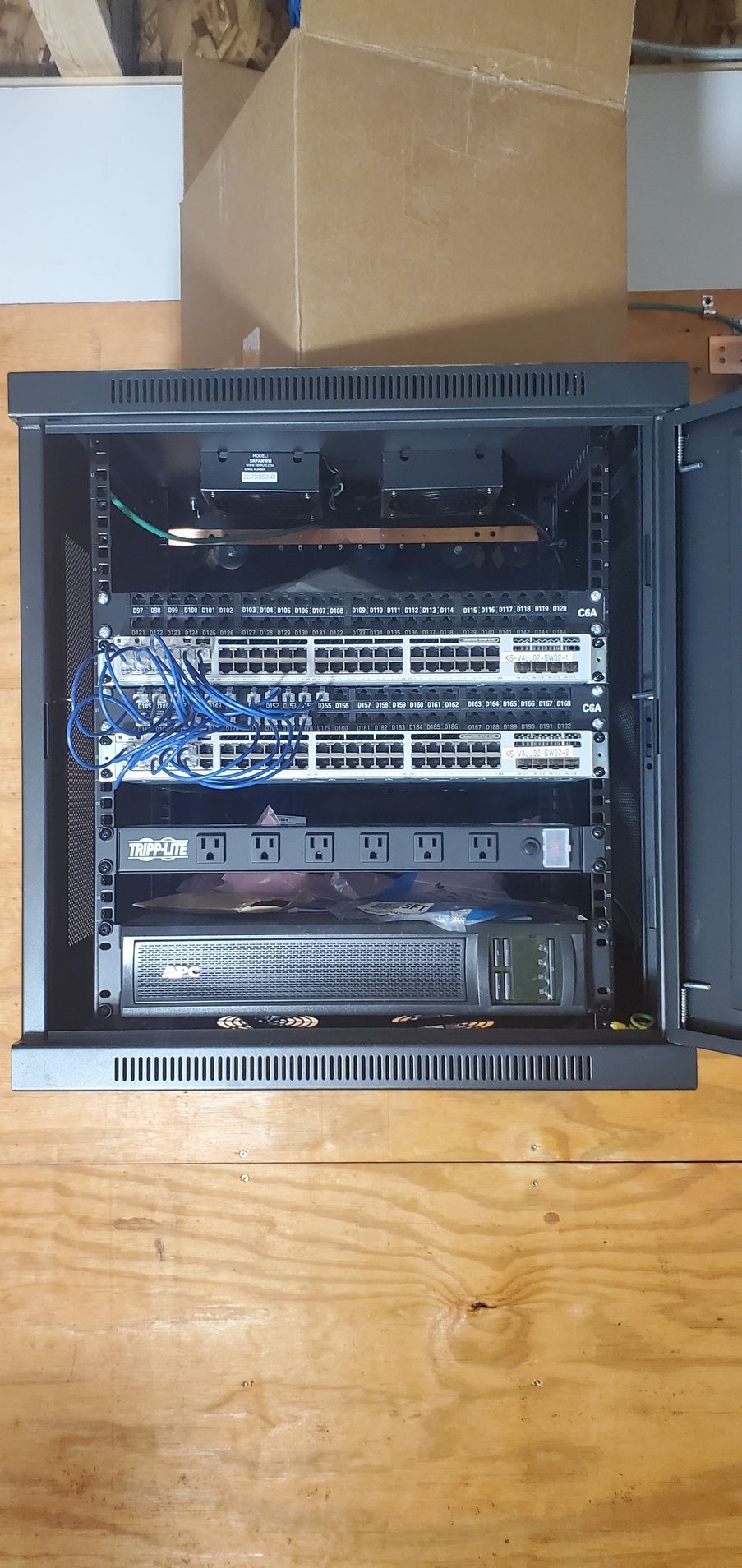A server rack is sitting on top of a wooden table.