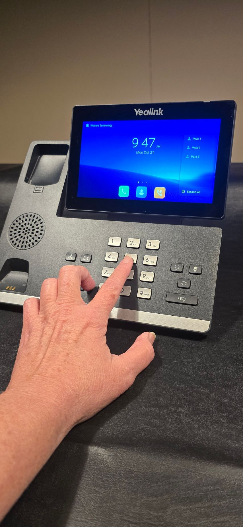 A person is pressing a button on a telephone.