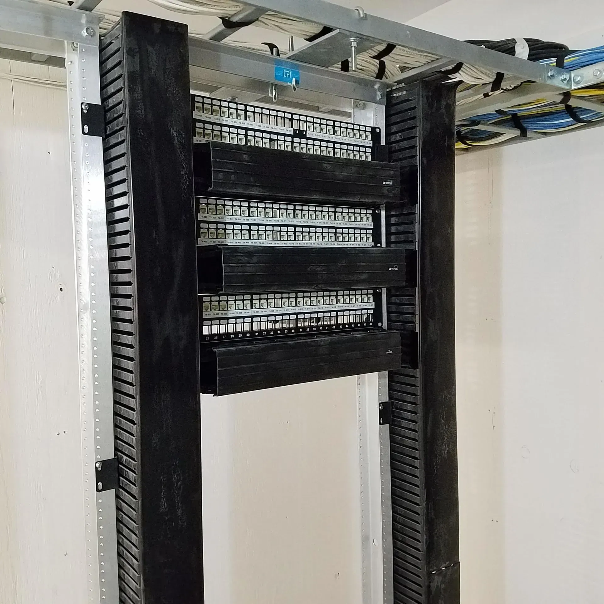 A server rack with a lot of wires hanging from it