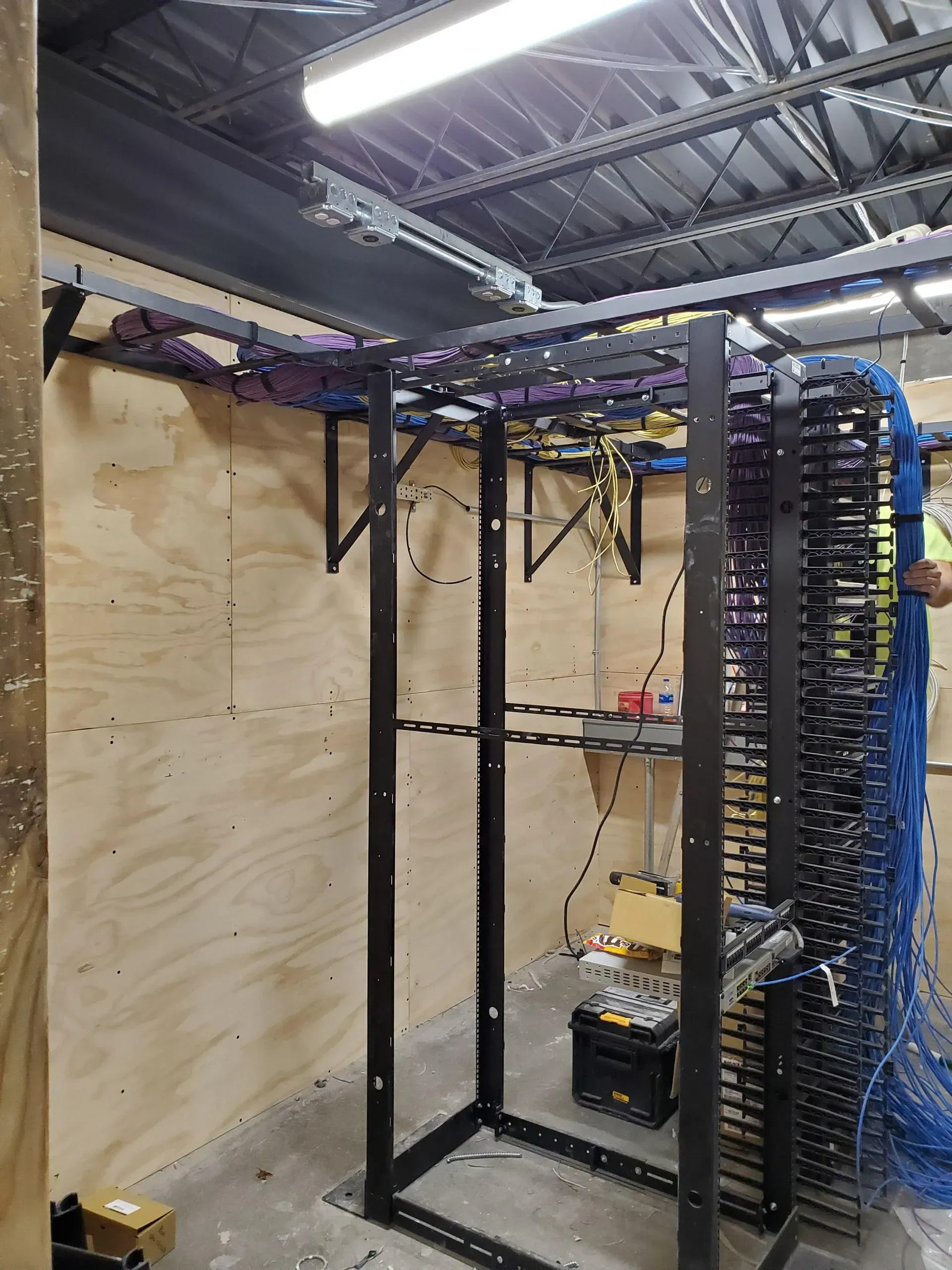 A rack with a lot of wires hanging from it in a room.