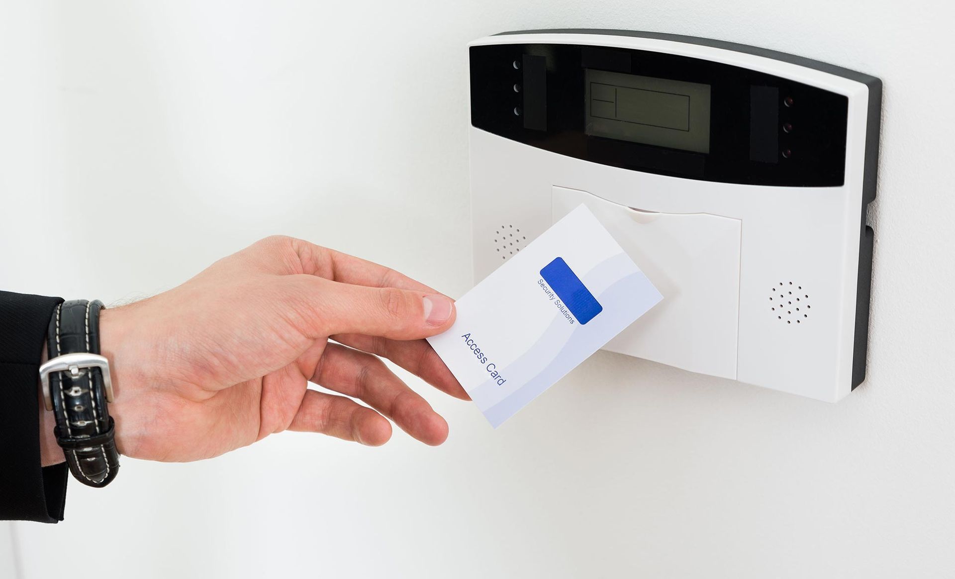 A person is inserting a card into a security system.