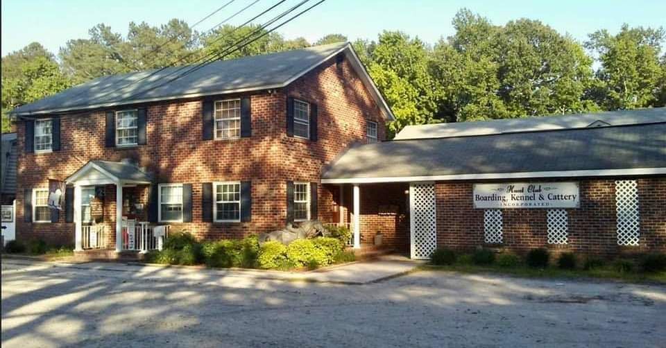 Two-story brick building with dark shutters and a small porch.