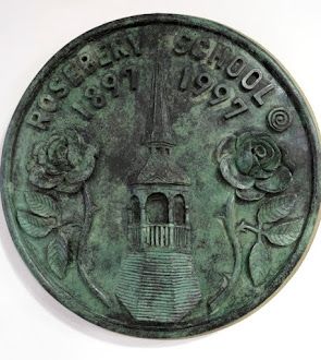 A bronze coin with roses and a tower on it