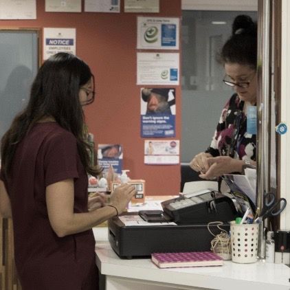Two women are standing at a counter in a hospital.