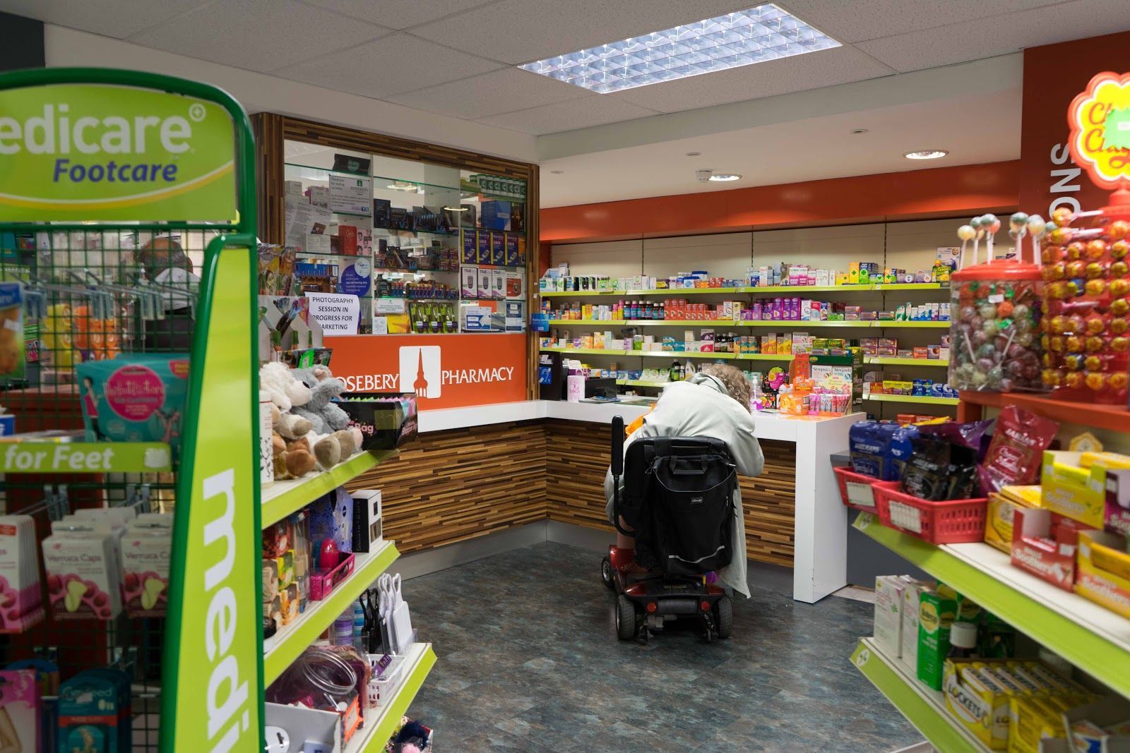A man in a mobility scooter is standing in a store.