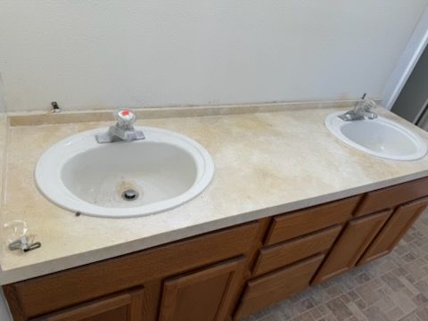 A bathroom with two sinks and wooden cabinets