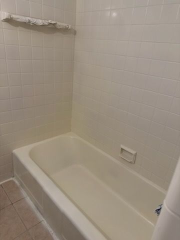 Bathtub in the bathroom with white tiles