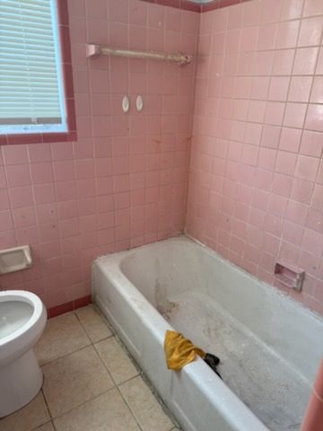 A bathroom with pink tiles before