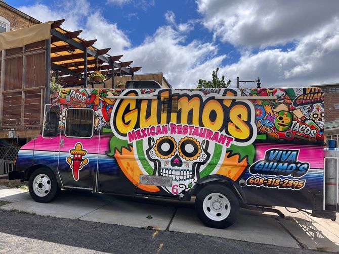 A colorful food truck is parked on the side of the road.