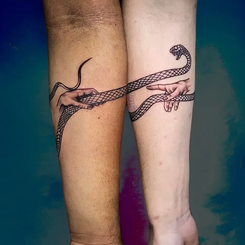 Un par de personas con tatuajes iguales en sus antebrazos.