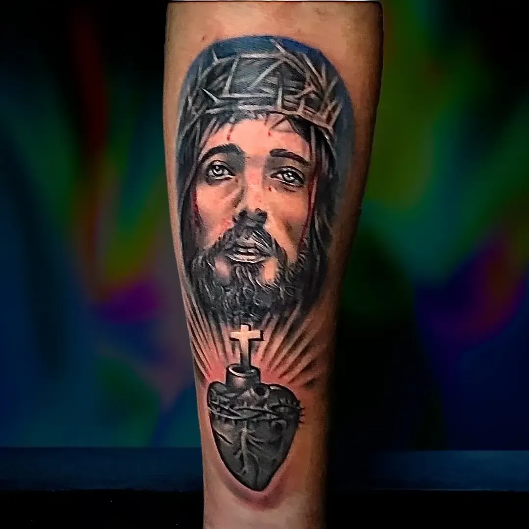 Un tatuaje de Jesús con una corona de espinas y un corazón.