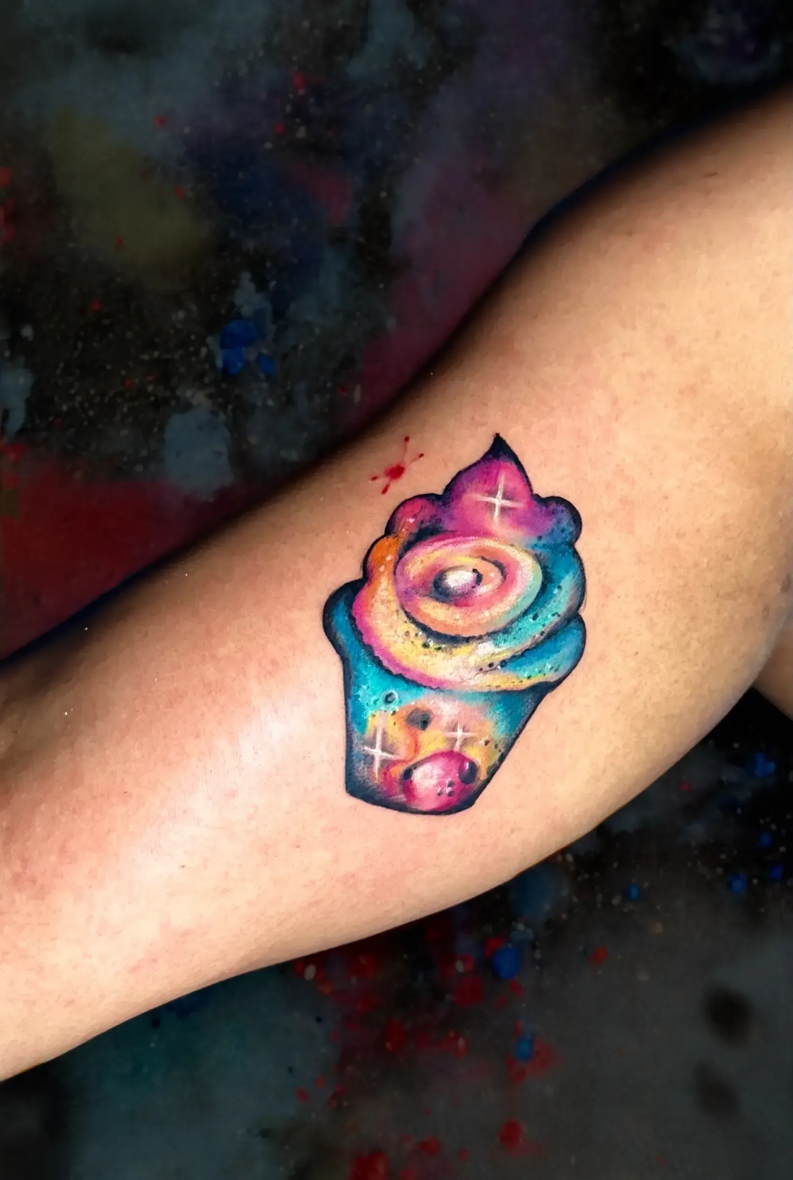 Una persona tiene un tatuaje de una magdalena en el brazo.