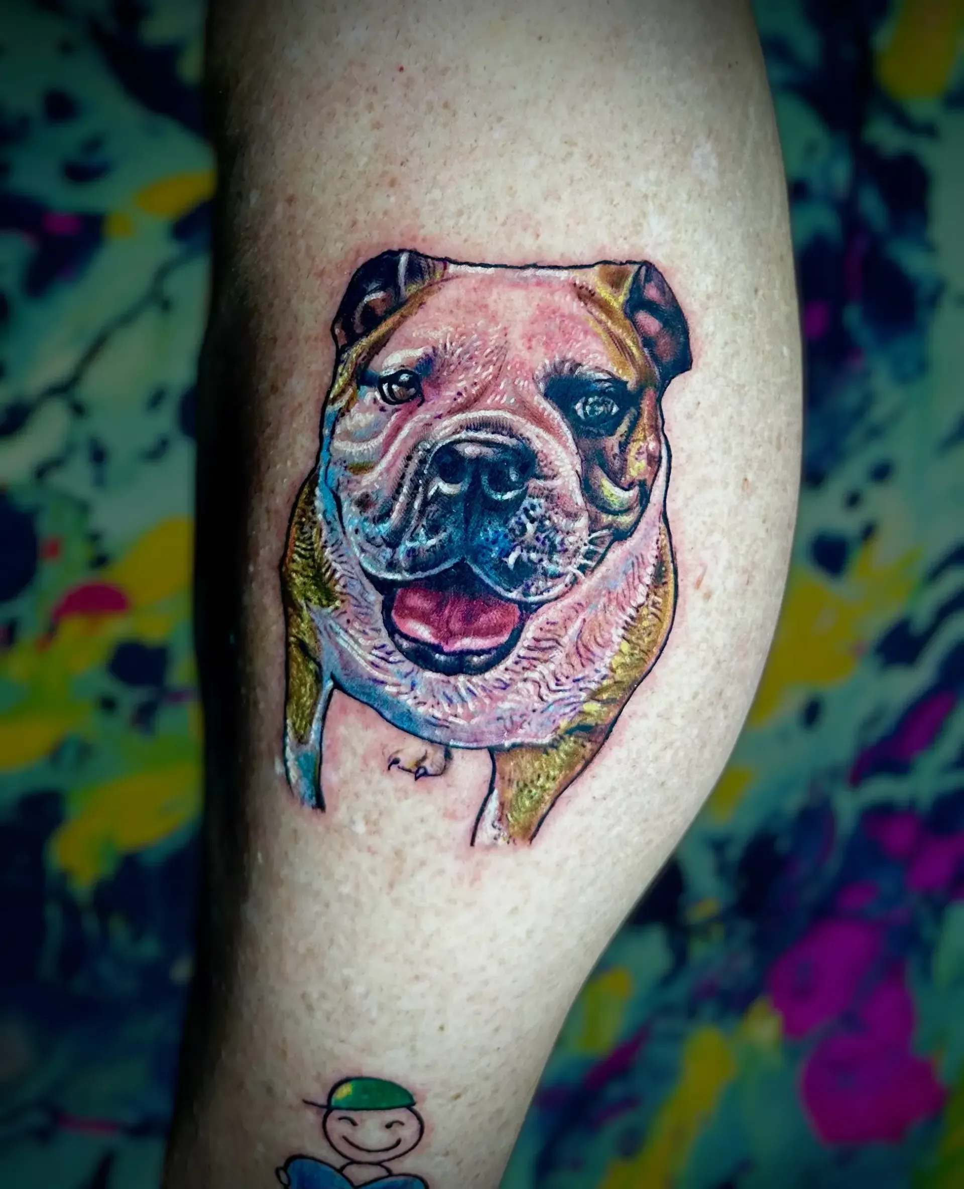Un tatuaje de un bulldog en la pierna de una persona.