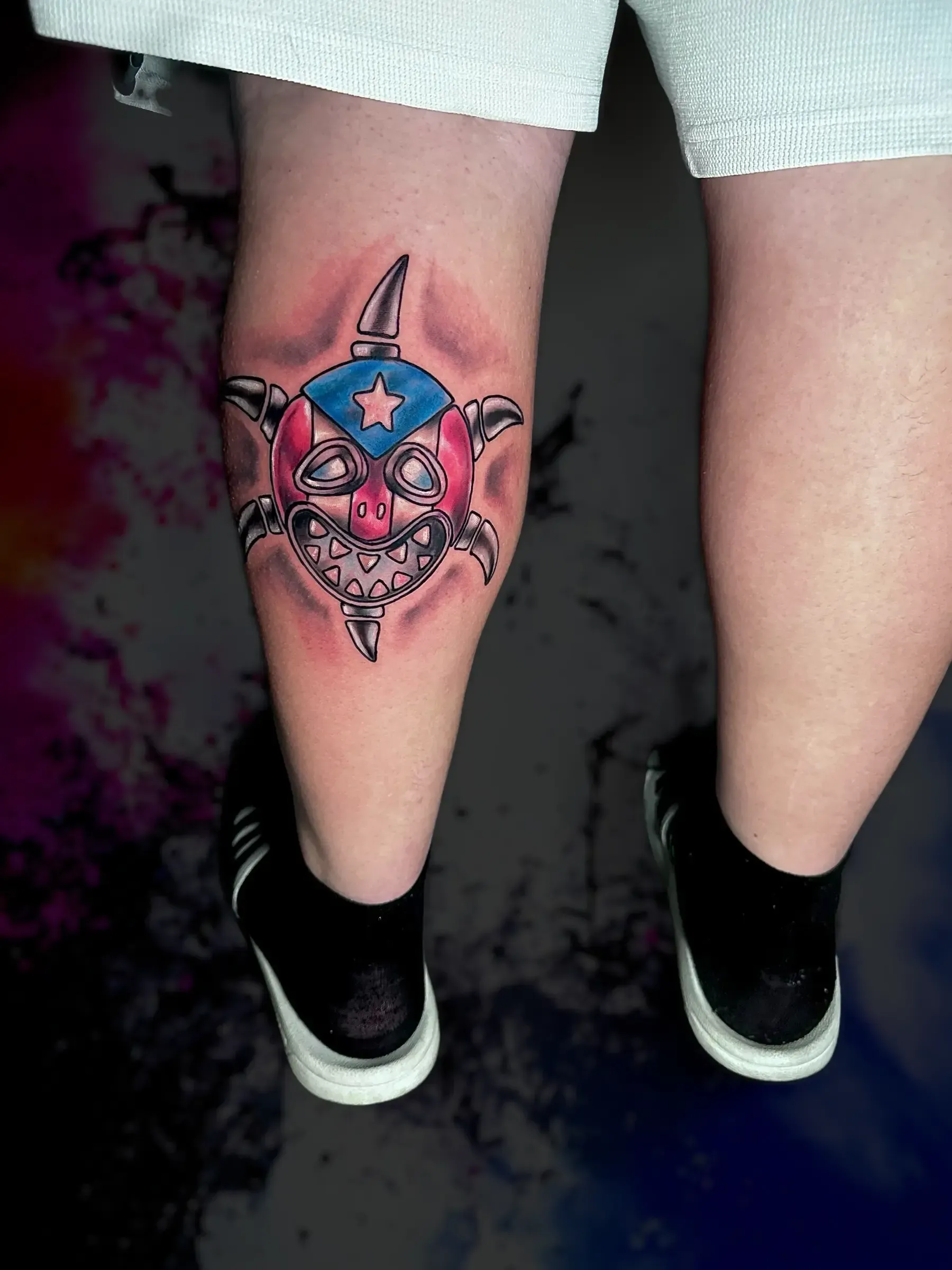 Una persona tiene un tatuaje de un tiburón en la pierna.