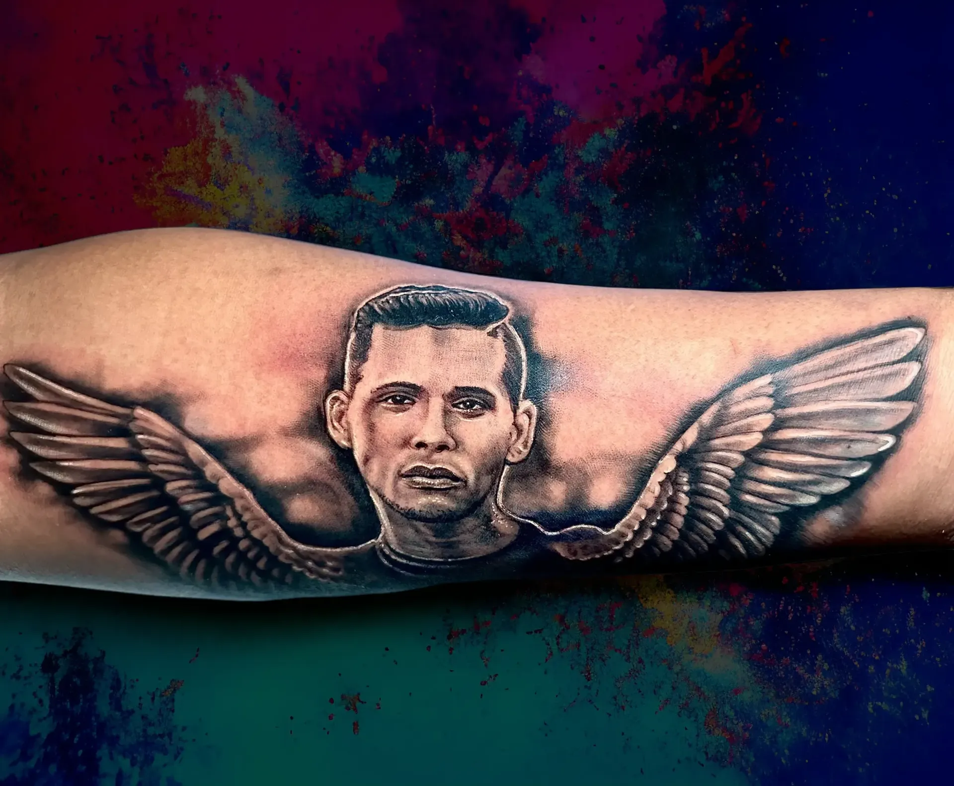 Un tatuaje de un hombre con alas en su brazo.