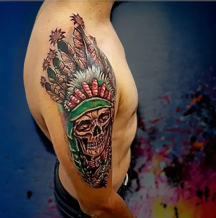 Un hombre tiene un tatuaje de una calavera y lleva un tocado nativo americano.
