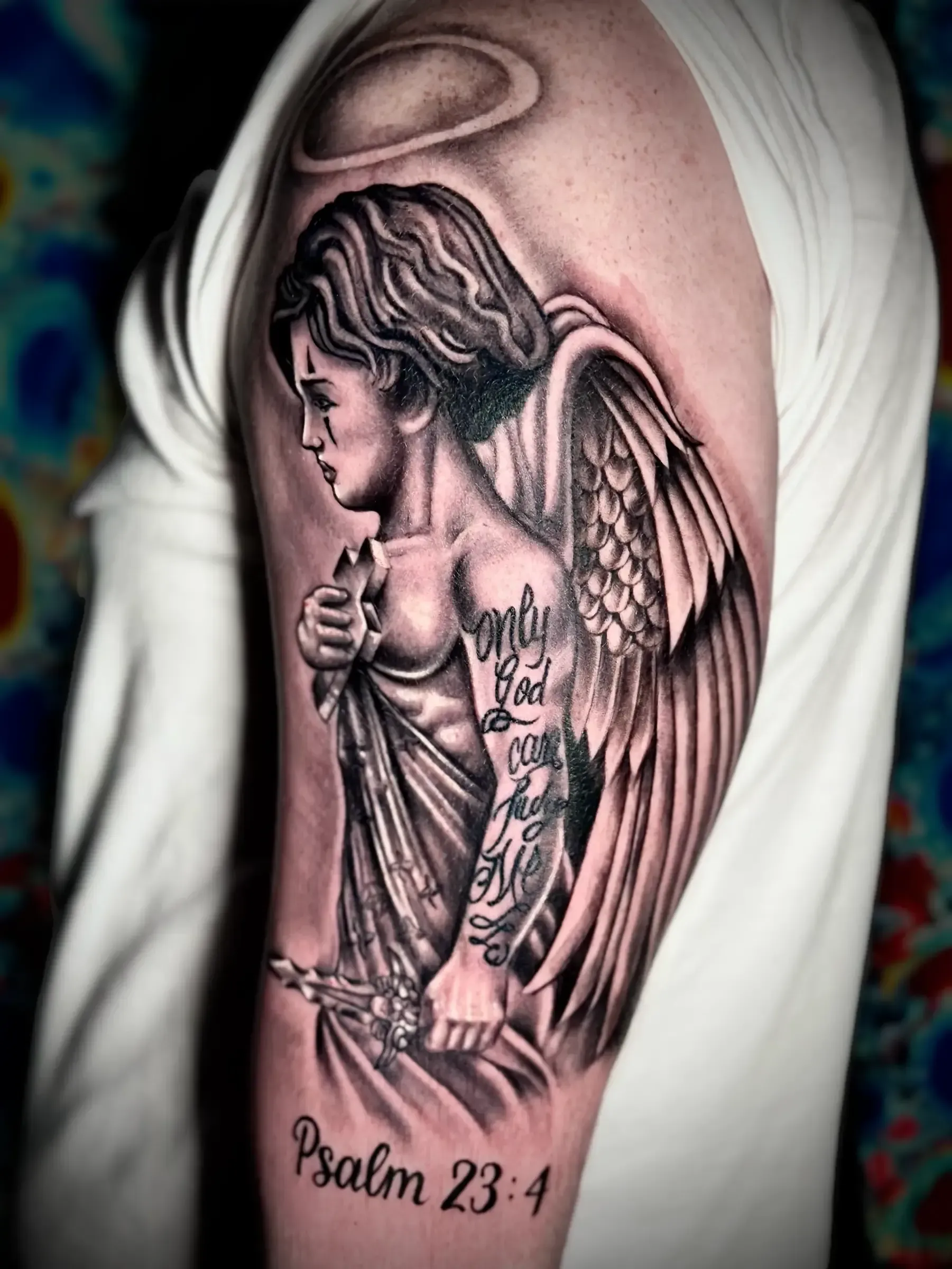 Un hombre tiene un tatuaje de un ángel en su brazo.