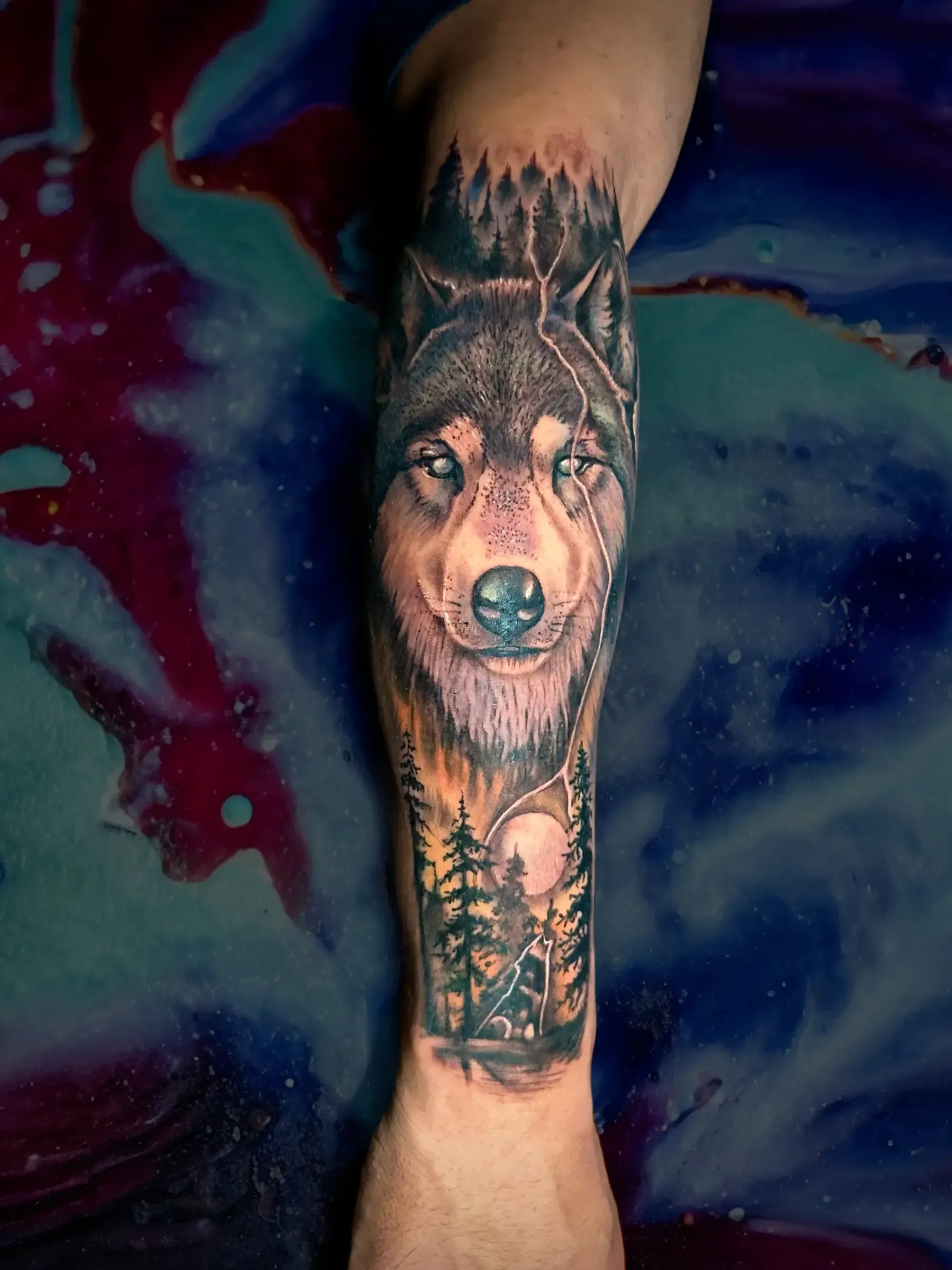 Una persona tiene un tatuaje de un lobo en su antebrazo.