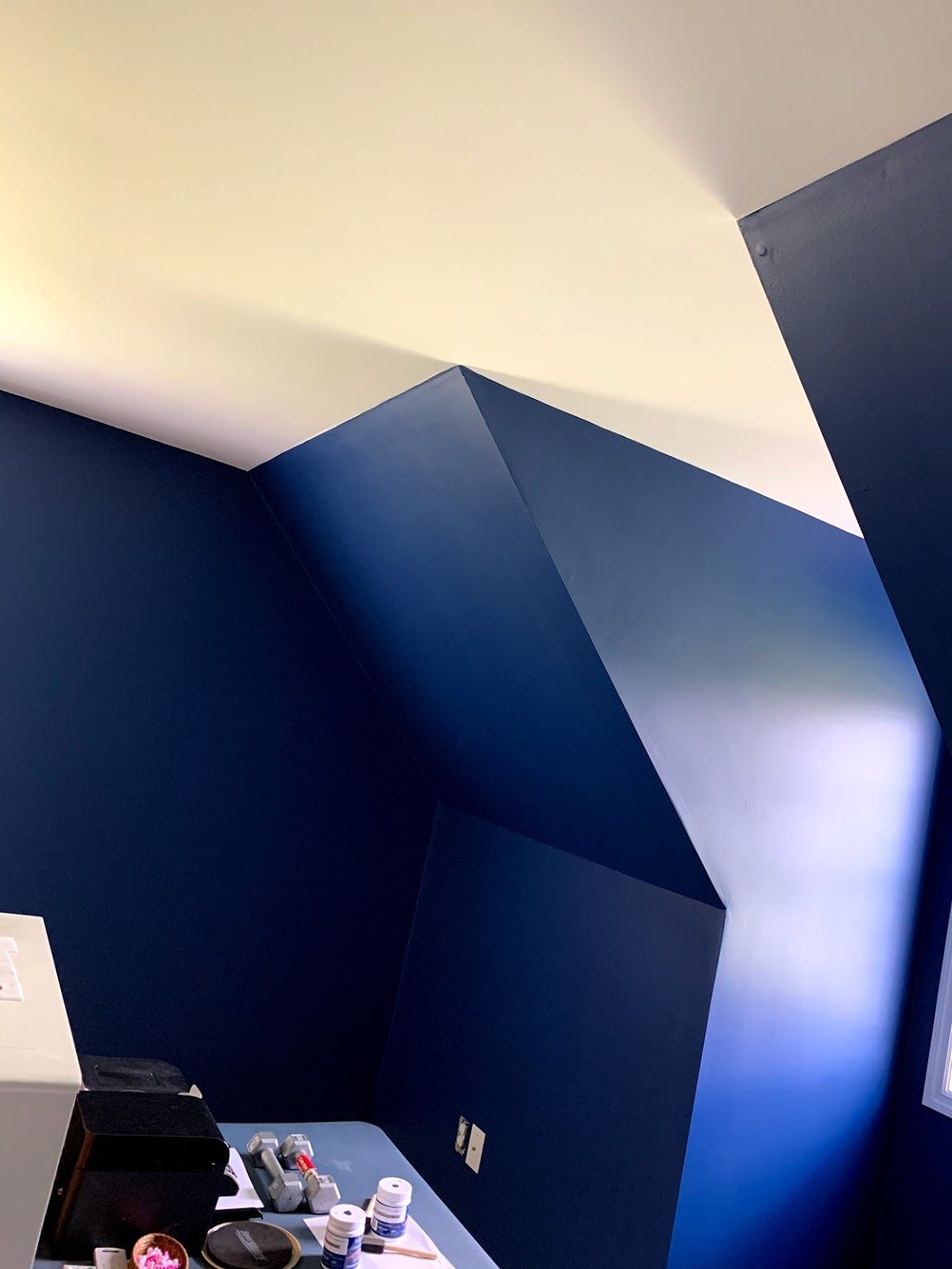 Navy blue painted room with angled walls and white ceiling.