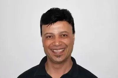 A man in a black shirt is smiling for the camera.