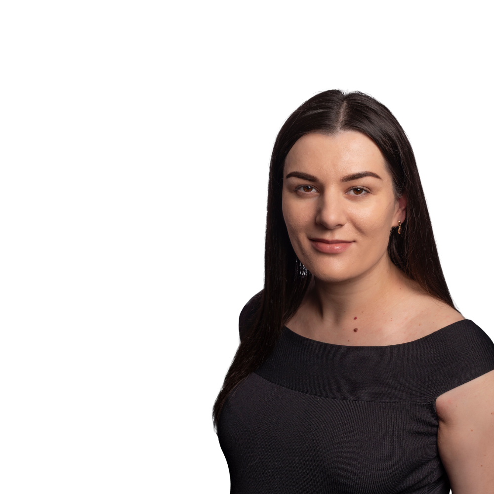 A headshot of a person with long dark hair, wearing a dark off-the-shoulder top against a plain white background.