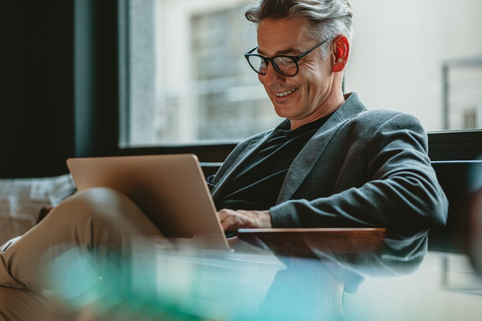 Man sitting at a desk using a laptop in a modern office