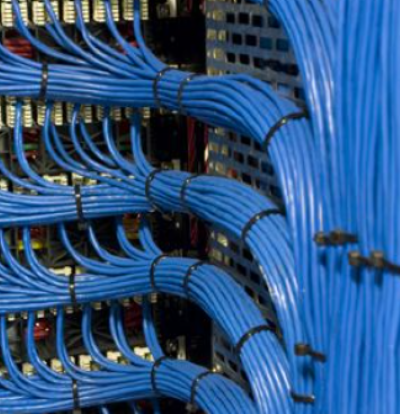 A bunch of blue wires are connected to each other in a server room.